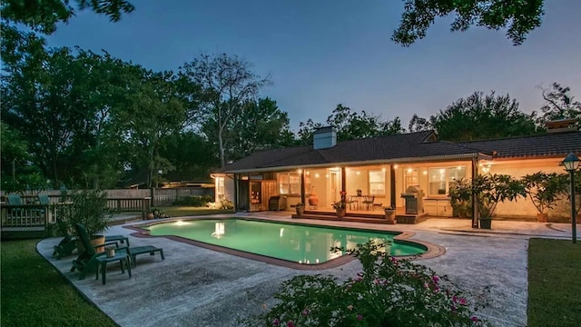 pool at dusk with a patio