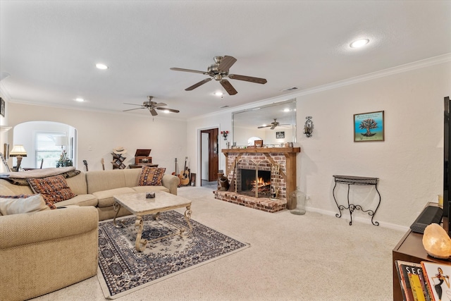 living room with ceiling fan, a fireplace, carpet, and ornamental molding