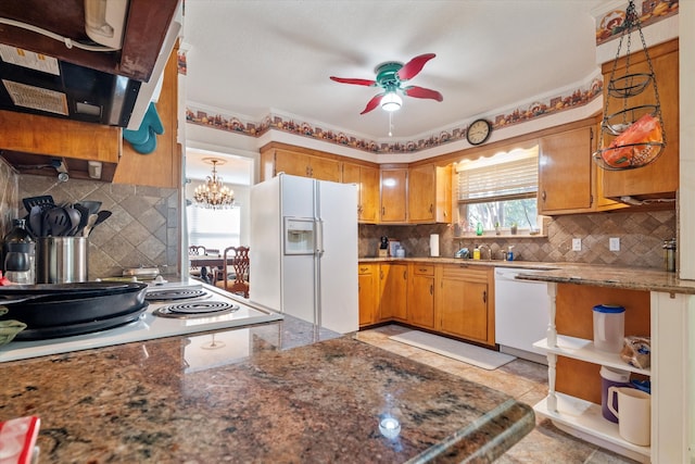 kitchen featuring white appliances, backsplash, ceiling fan with notable chandelier, decorative light fixtures, and extractor fan