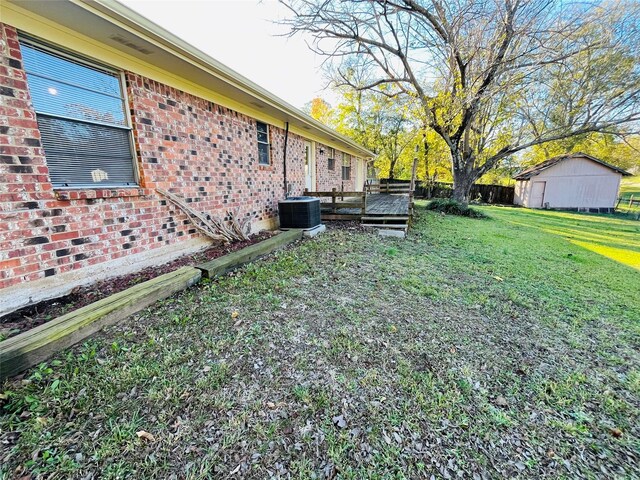 view of yard featuring a wooden deck and central AC