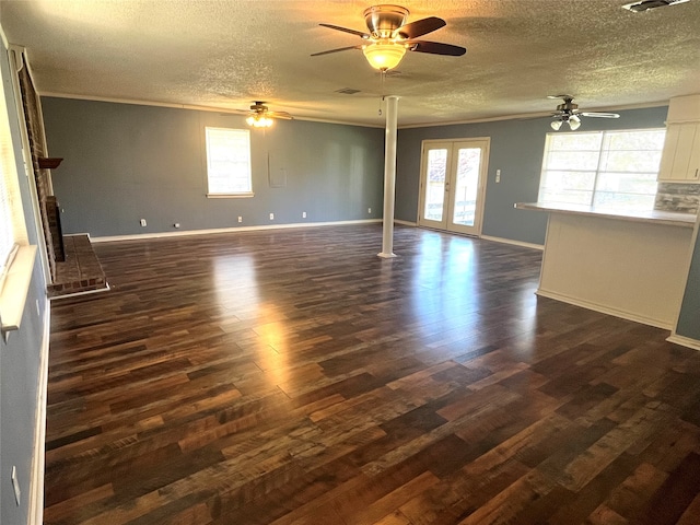 unfurnished living room with a textured ceiling, a brick fireplace, ceiling fan, and dark wood-type flooring