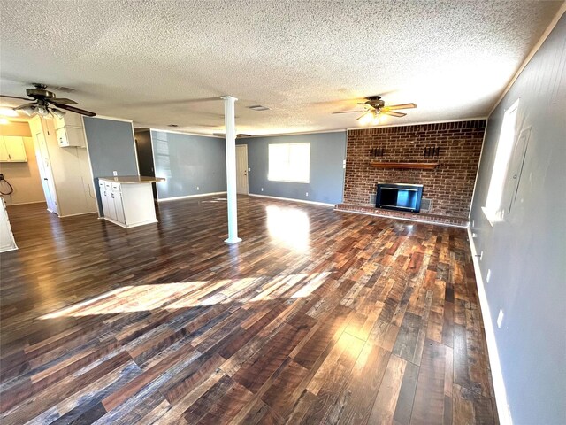 unfurnished living room with a textured ceiling, dark hardwood / wood-style flooring, crown molding, and sink