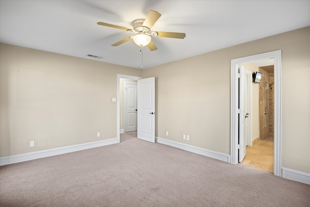 unfurnished bedroom featuring ceiling fan, ensuite bathroom, and light carpet