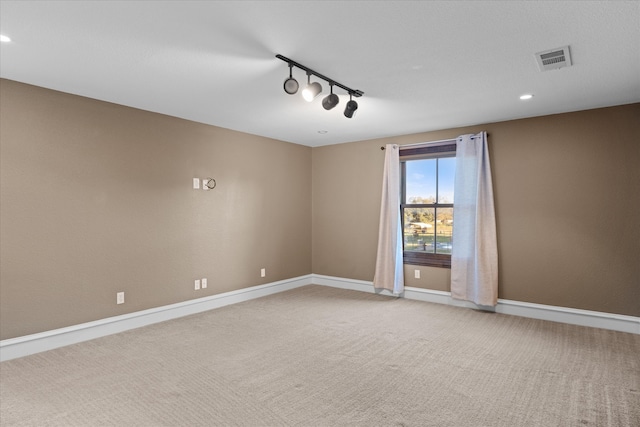 carpeted spare room featuring recessed lighting, rail lighting, baseboards, and visible vents