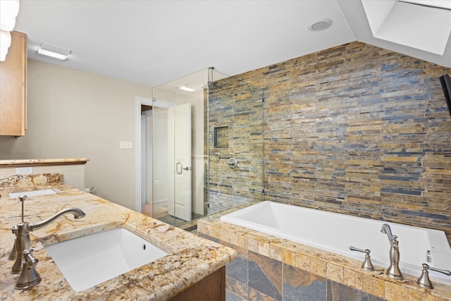 bathroom featuring vanity and independent shower and bath