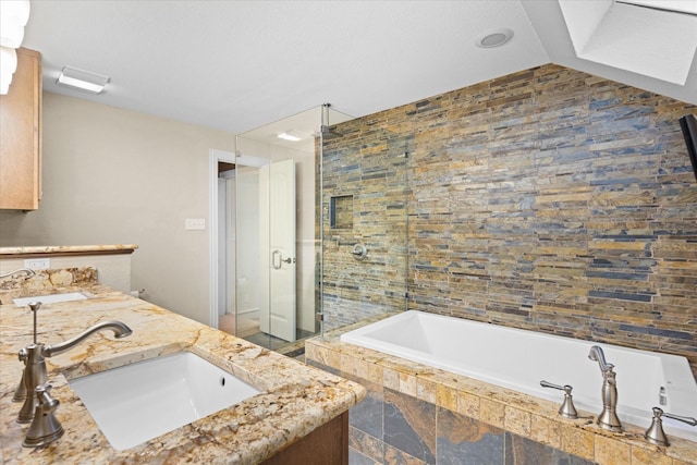 bathroom featuring vaulted ceiling, a stall shower, tiled tub, and a sink