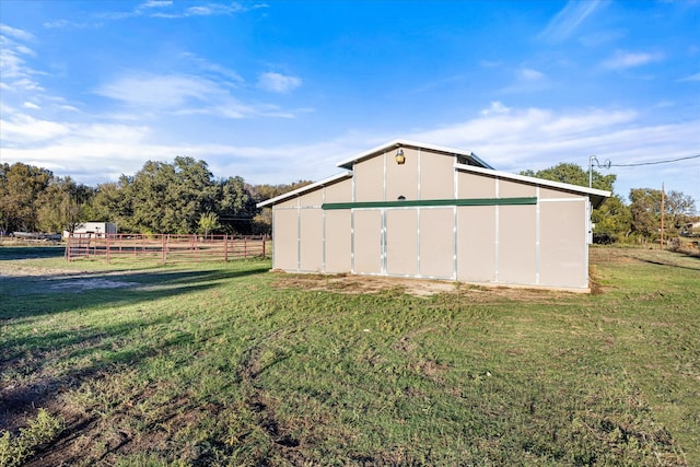 view of outdoor structure with a rural view and a lawn