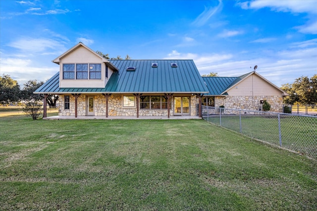 view of front of house featuring stone siding, a front lawn, and a standing seam roof