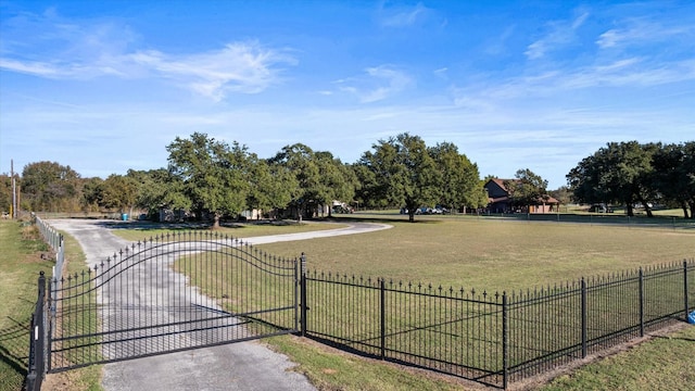 view of property's community with a gate, a yard, and fence