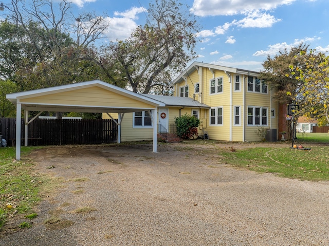 view of front of home with central AC unit and a carport