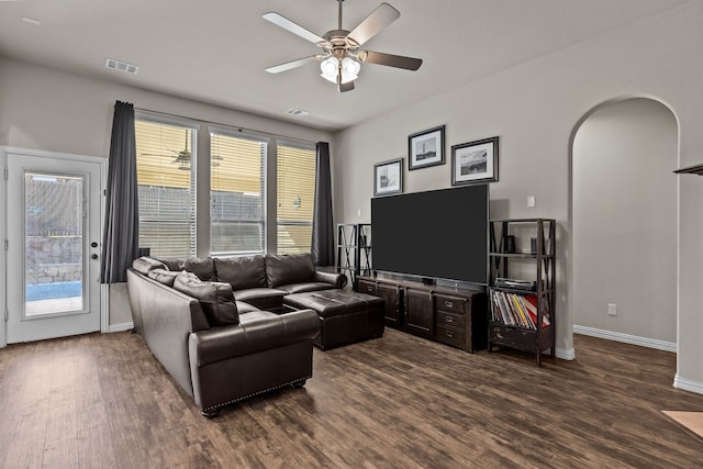 living room featuring ceiling fan and dark wood-type flooring