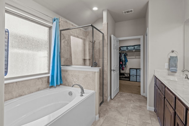 bathroom featuring tile patterned floors, vanity, and plus walk in shower