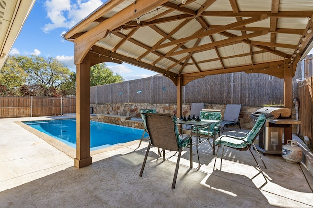 view of pool featuring a gazebo, area for grilling, and a patio area