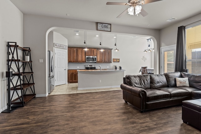 living room with hardwood / wood-style floors, ceiling fan, and sink