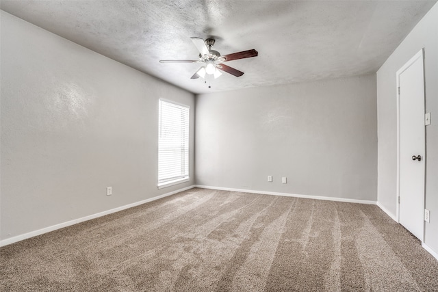 carpeted spare room featuring ceiling fan and a textured ceiling