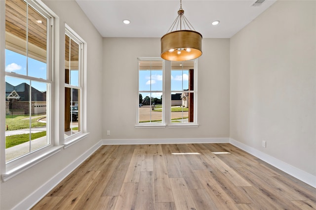 unfurnished dining area with light wood-type flooring and a wealth of natural light