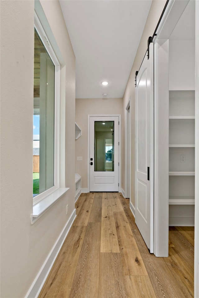 hall featuring a barn door and light wood-type flooring