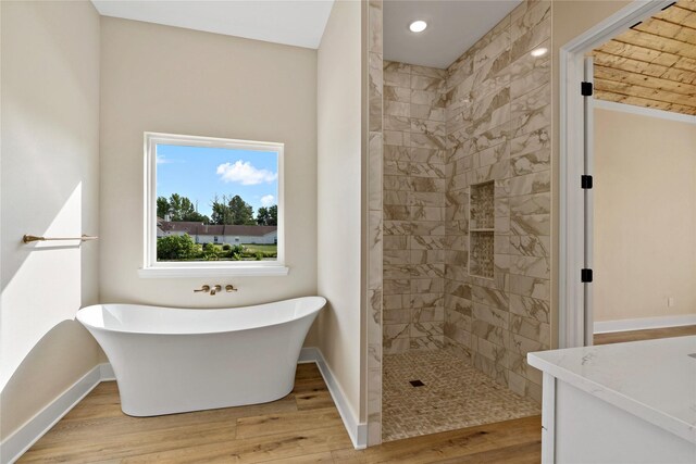 bathroom featuring separate shower and tub, hardwood / wood-style floors, and vanity