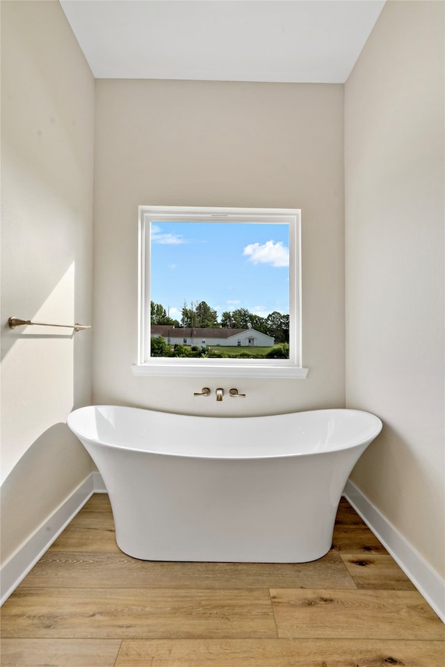 bathroom with hardwood / wood-style floors and a tub