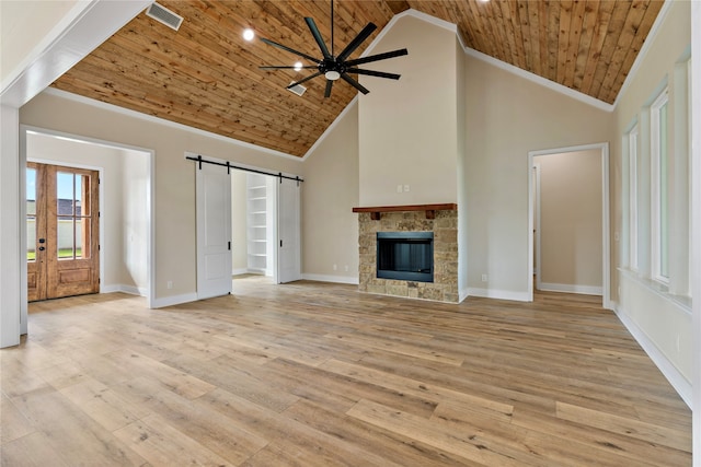 unfurnished living room with a barn door, high vaulted ceiling, wooden ceiling, and light wood-type flooring