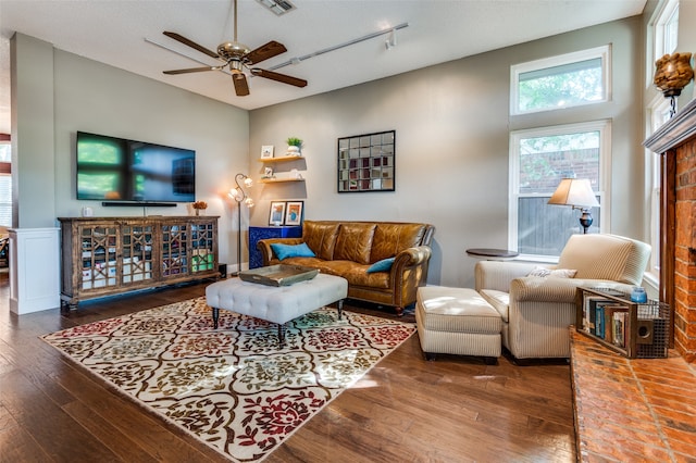 living room with a textured ceiling, dark hardwood / wood-style flooring, and ceiling fan