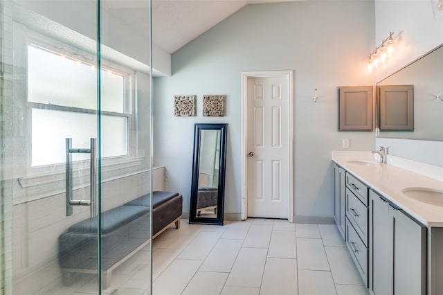 bathroom with tile patterned flooring, vanity, vaulted ceiling, and a shower with shower door