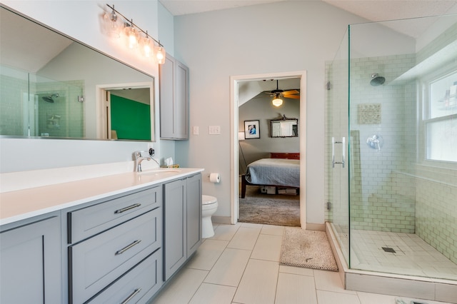 bathroom featuring ceiling fan, tile patterned flooring, vaulted ceiling, vanity, and a shower with shower door