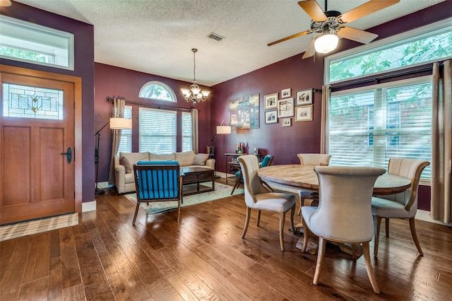 dining space featuring ceiling fan with notable chandelier, wood-type flooring, and a textured ceiling