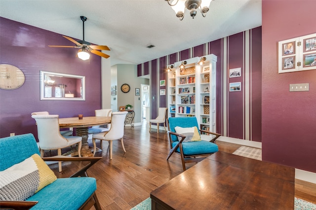 dining area featuring ceiling fan, wood-type flooring, a textured ceiling, and vaulted ceiling