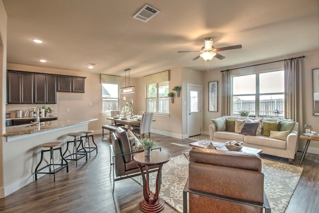 living room featuring ceiling fan, dark hardwood / wood-style flooring, and sink