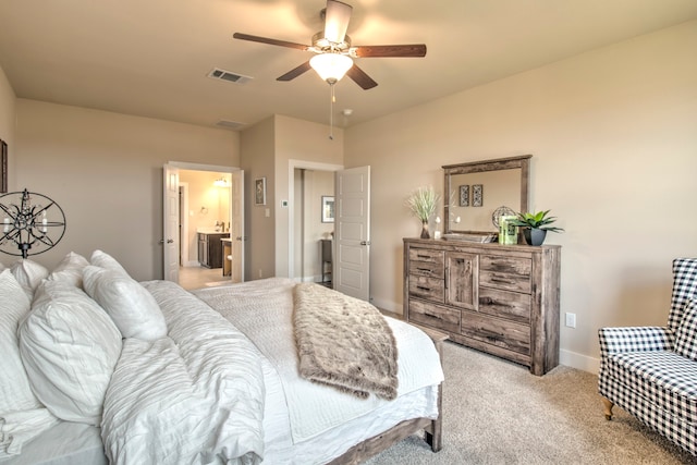 bedroom featuring light colored carpet, ensuite bath, and ceiling fan