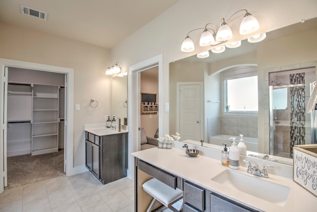 bathroom featuring tile patterned flooring, vanity, and shower with separate bathtub