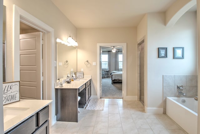 bathroom featuring tile patterned floors, vanity, ceiling fan, and a bathing tub