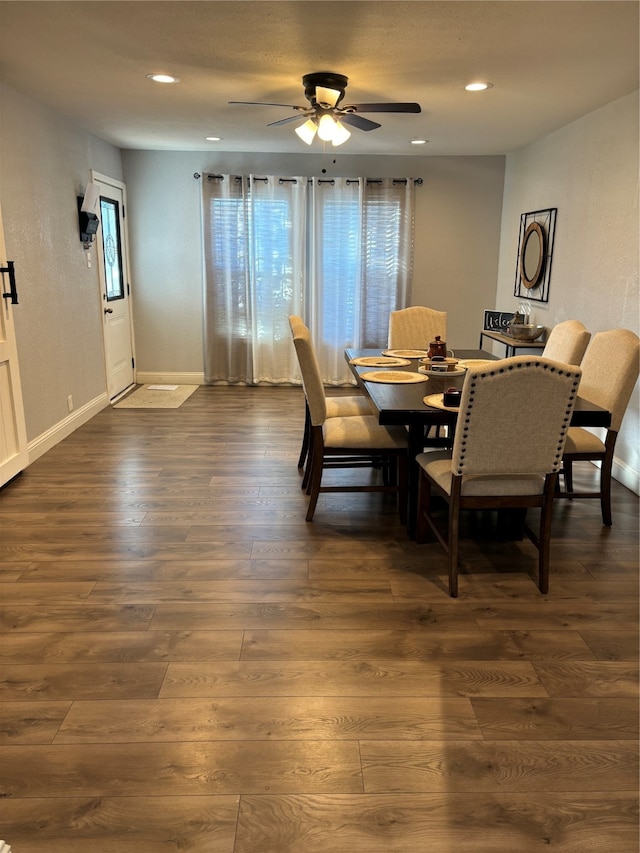 dining room with ceiling fan, a healthy amount of sunlight, and dark wood-type flooring