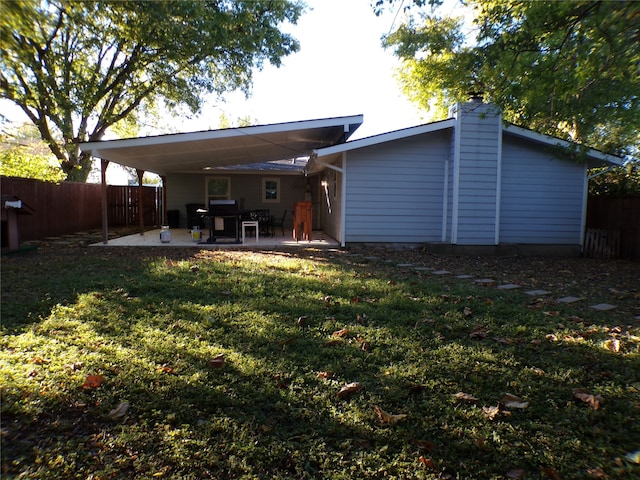 rear view of property with a yard and a patio