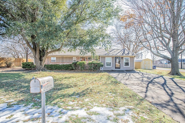 ranch-style house featuring a storage shed and a front yard