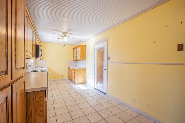 kitchen featuring ceiling fan, white electric range, wooden walls, ornamental molding, and light tile patterned floors