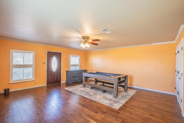 entrance foyer with ceiling fan, a healthy amount of sunlight, dark wood-type flooring, and ornamental molding