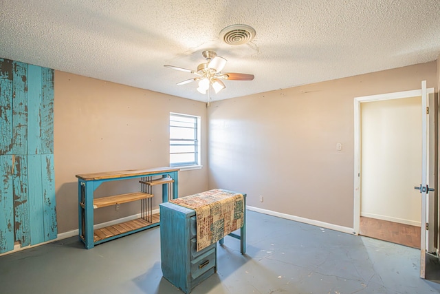 interior space featuring ceiling fan and a textured ceiling