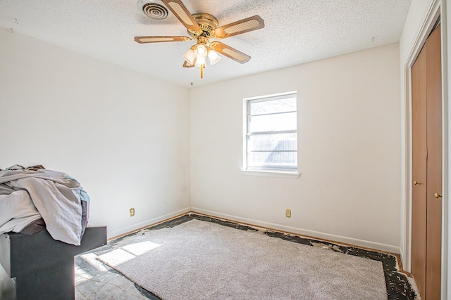 unfurnished bedroom with ceiling fan, a closet, and a textured ceiling