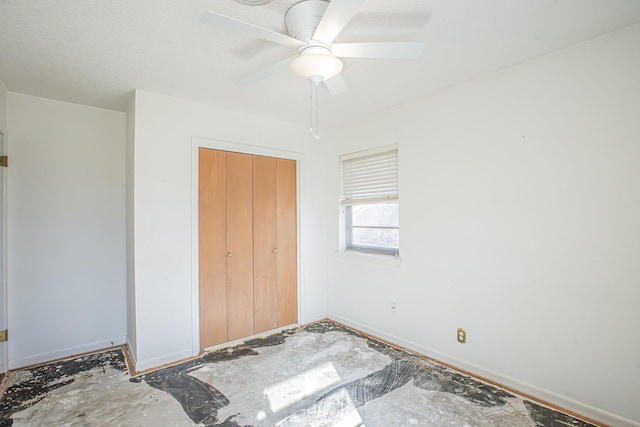 unfurnished bedroom featuring ceiling fan and a closet