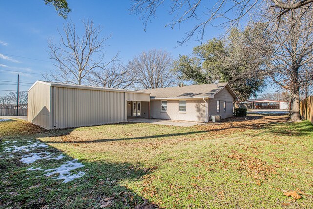 rear view of house with cooling unit and a yard