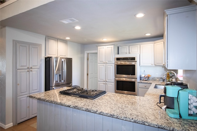 kitchen featuring kitchen peninsula, white cabinetry, and stainless steel appliances