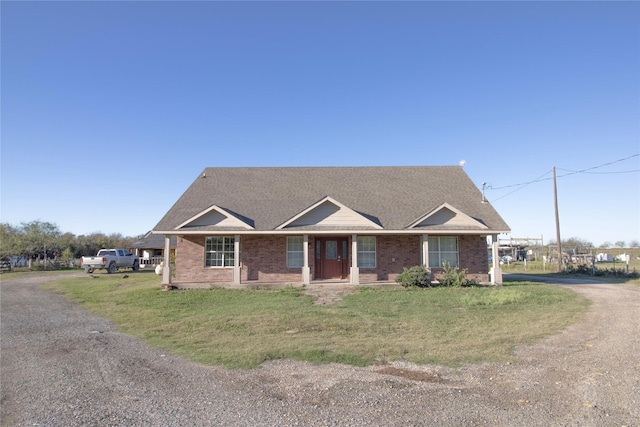 332 NW County Road 2005, Corsicana, TX 75110 - view of front facade featuring brick siding, a front yard, a shingled roof, and covered porch