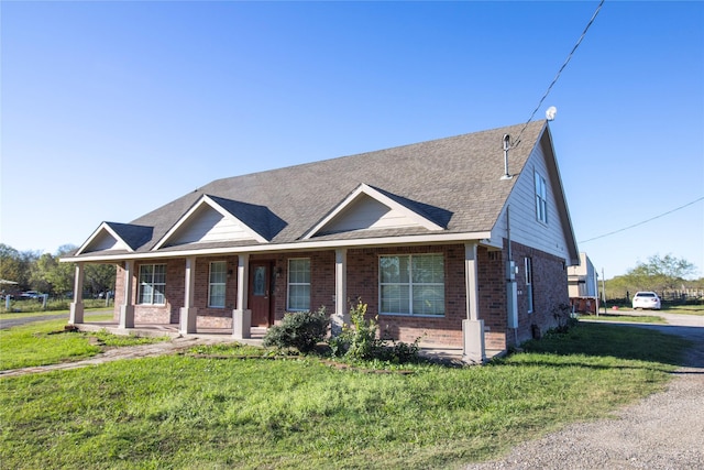 332 NW County Road 2005, Corsicana, TX 75110 - view of front facade with brick siding, a front lawn, a shingled roof, and a porch