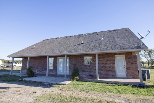 332 NW County Road 2005, Corsicana, TX 75110 - rear view of property with a shingled roof, brick siding, and a patio