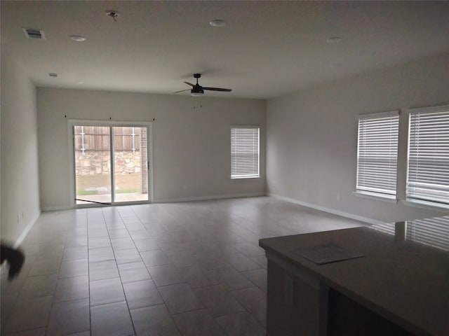 tiled spare room featuring ceiling fan