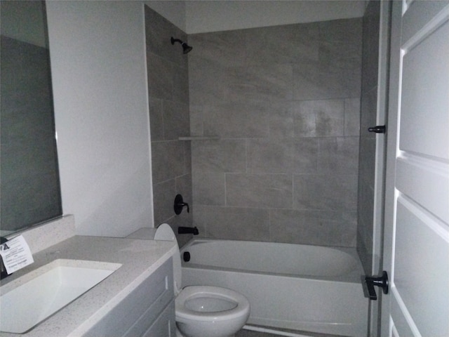 full bathroom featuring vanity, tiled shower / bath combo, and toilet