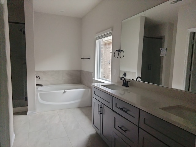 bathroom featuring plus walk in shower, vanity, and tile patterned floors