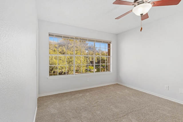 carpeted empty room featuring ceiling fan and a textured ceiling